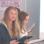 A group of Practical Action Schools girls standing in front of a projector during the Highlights of 2018.