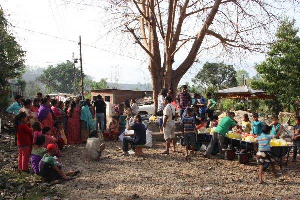 A group of people participating in the Nepal Reconstruction Campaign gathered around a tree.