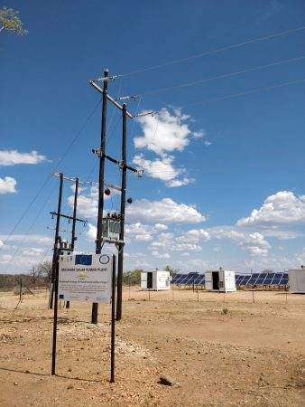 A field with solar panels providing electricity for impoverished communities.