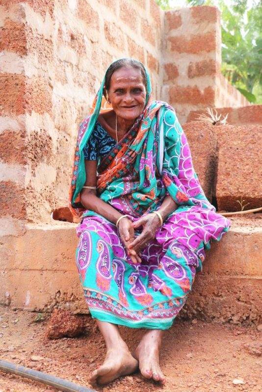 An Indian woman ingeniously sitting on a brick wall, changing lives with water and waste solutions.