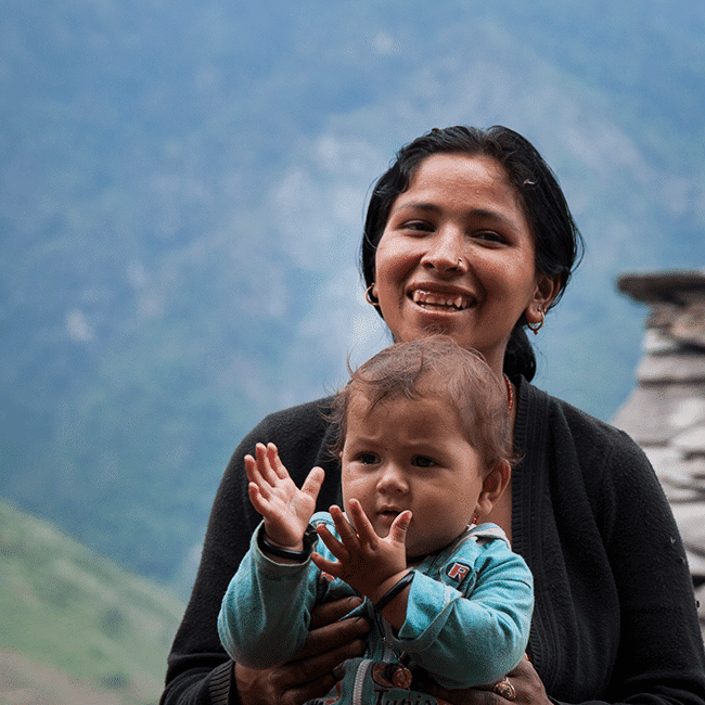A woman connecting with a child in front of a mountain.