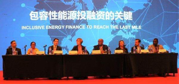A group of people discussing the challenge of scaling-up energy access at a conference table.