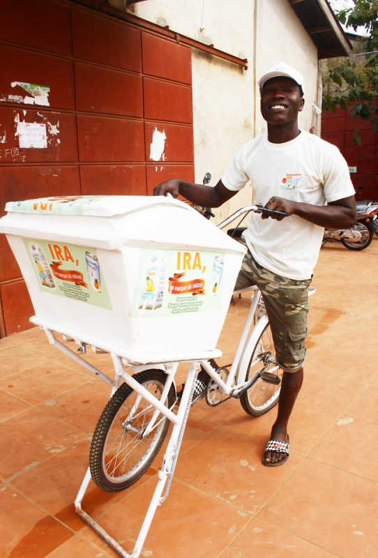 A man representing a global collective on a bicycle with a box.