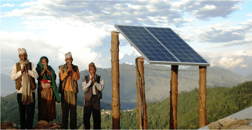 A group of people engaging in personal philanthropy in front of a solar panel.