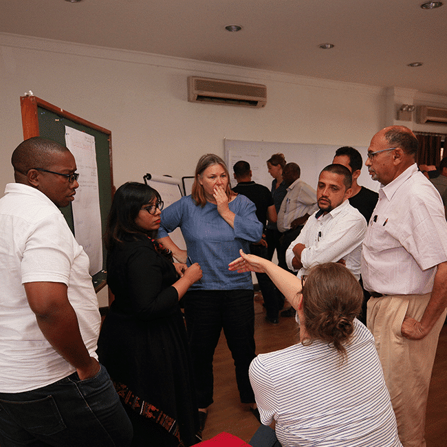 A group of people working with Practical Action in a room.