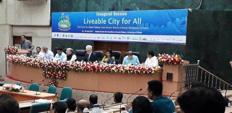 Slum dwellers confront politicians in Bangladesh while sitting at a table in front of a banner.