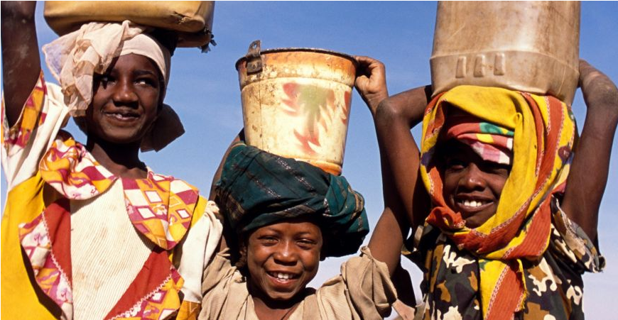 Three children wearing buckets on their heads, playing with water.