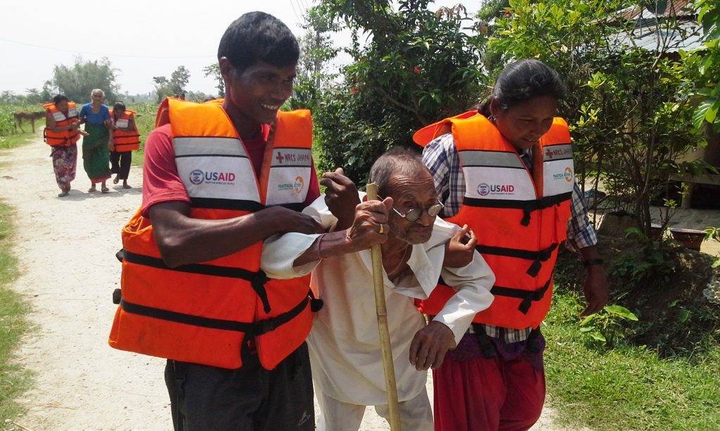 A group of people in life jackets practicing walking down a path in Nepal.