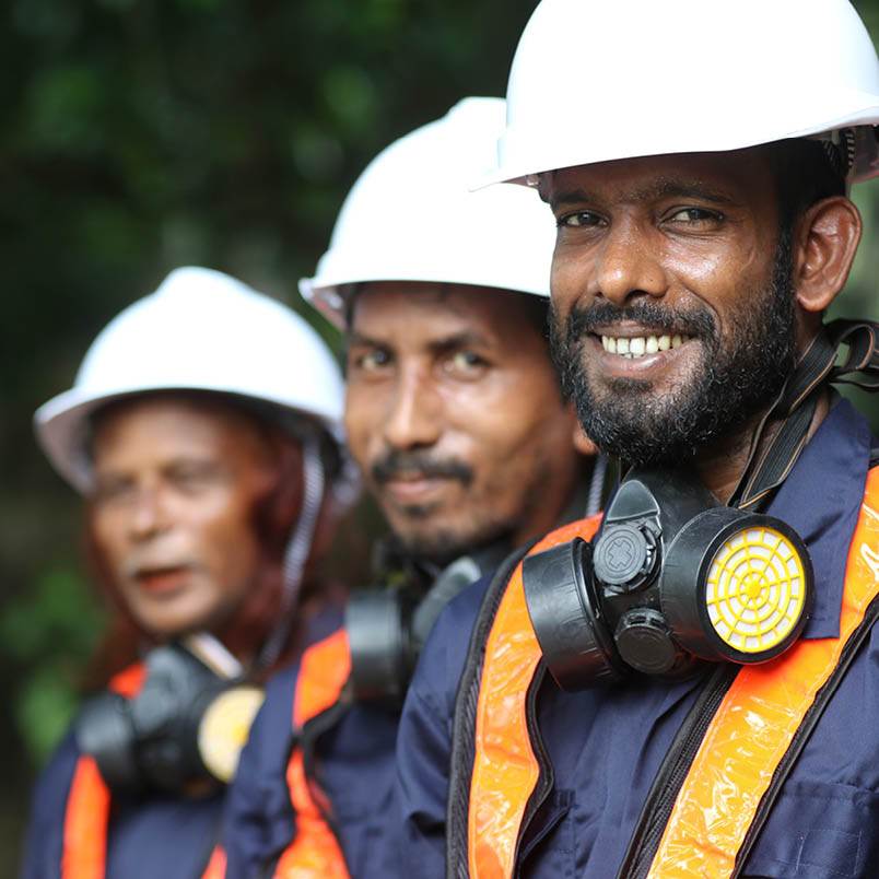 A group of men wearing hard hats and gas masks