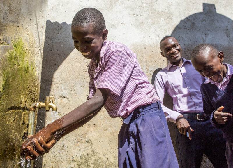 Boys washing hands at water fountain on World Toilet Day 2019.