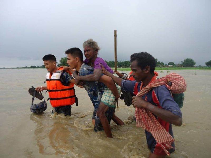 A group of people facing the climate crisis while walking through a flooded area.
