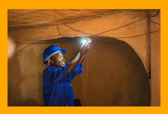 A boy exploring a cave with a flashlight while pursuing Cambridge Nationals in Engineering.