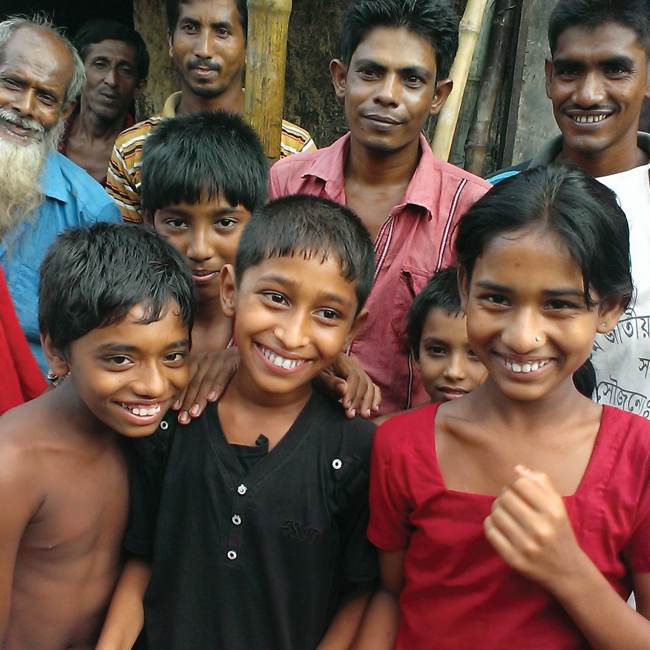 A group of people in a village smiling for the camera.