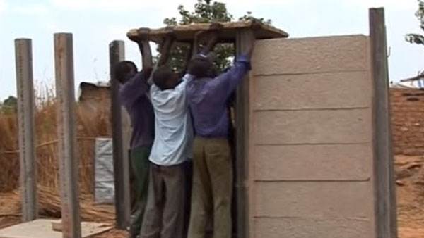 A team constructs a toilet in an open field for a water and sanitation video.