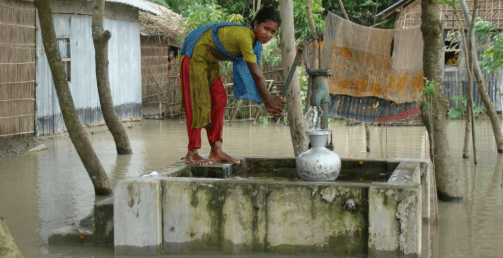 In this video, a woman is filling a water container amidst flooding.