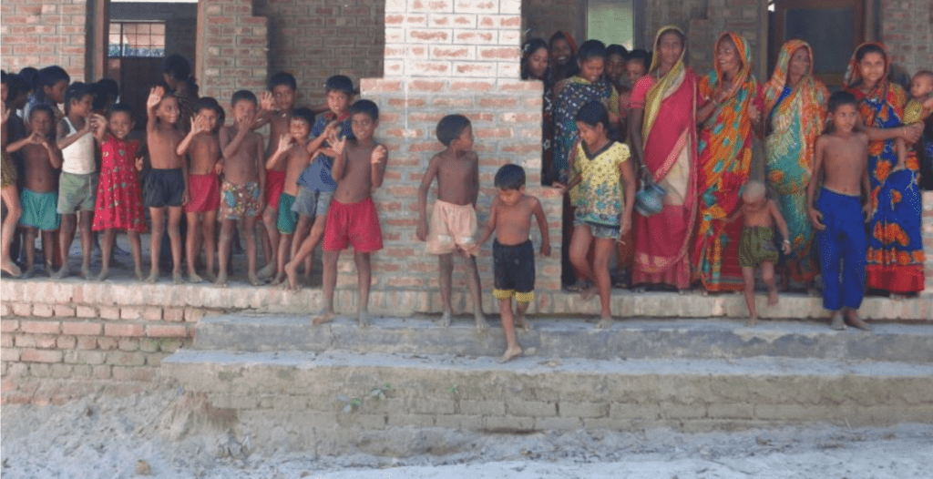 A group of children standing in front of a building, fascinated by marvellous microbes.