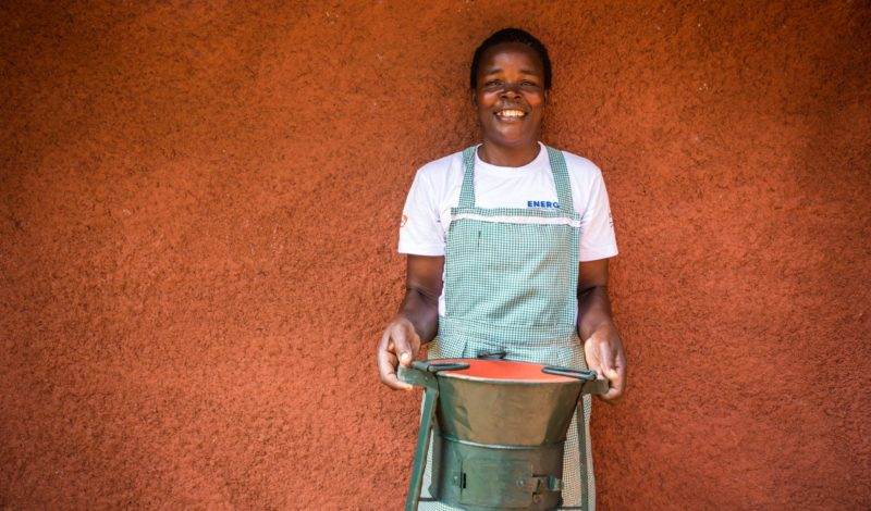 A woman in an apron gracefully holds a clay pot, embodying the energy that transforms in an annual report design.