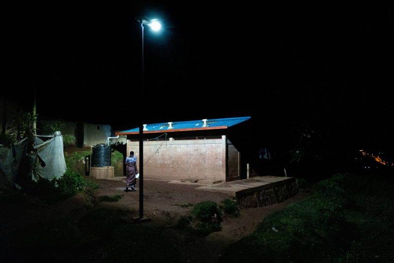 A small hut illuminated at night in a refugee camp, symbolizing the transformation into a city.