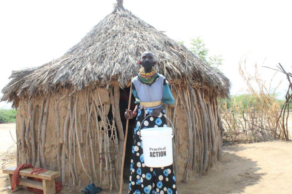 A woman in front of a hut tackling Coronavirus.
