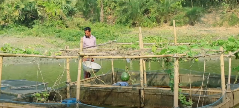 A man is turning climate crisis into resilience by standing on a floating platform in a river.
