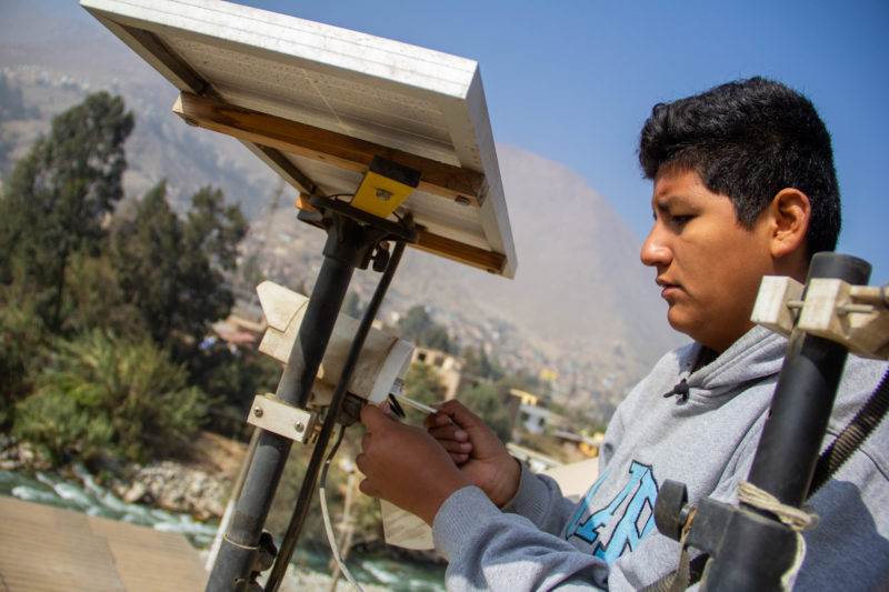 A young man is working on a solar panel.