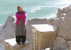 A woman standing on a set of steps next to a body of water.