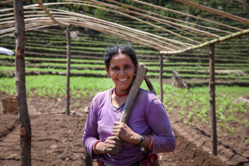 A woman utilizing a wooden stick to implement an ingenious five point plan benefiting farmers in Nepal to adapt to climate change.