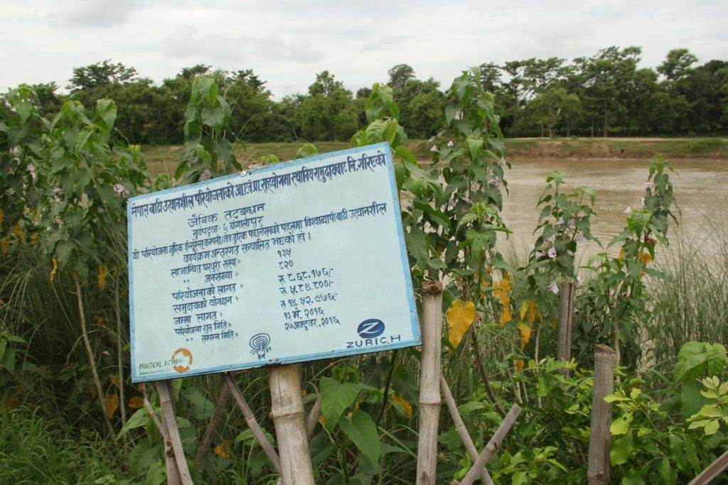 Indigenous ingenuity incorporates ancestral water management knowledge with a sign on the side of a river.