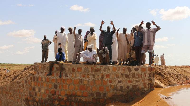 A group of people standing on top of a brick wall featured on the homepage.