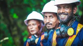 A group of men in hard hats are smiling while working on creating cities fit for people by utilizing resources efficiently.