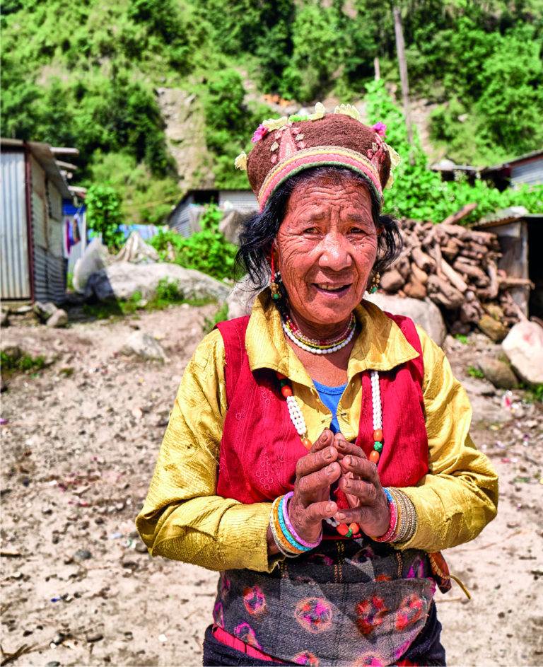 A woman undergoes gender transformative change in front of a house.