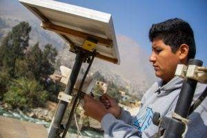 A young man is enhancing climate resilience by working on a solar panel.