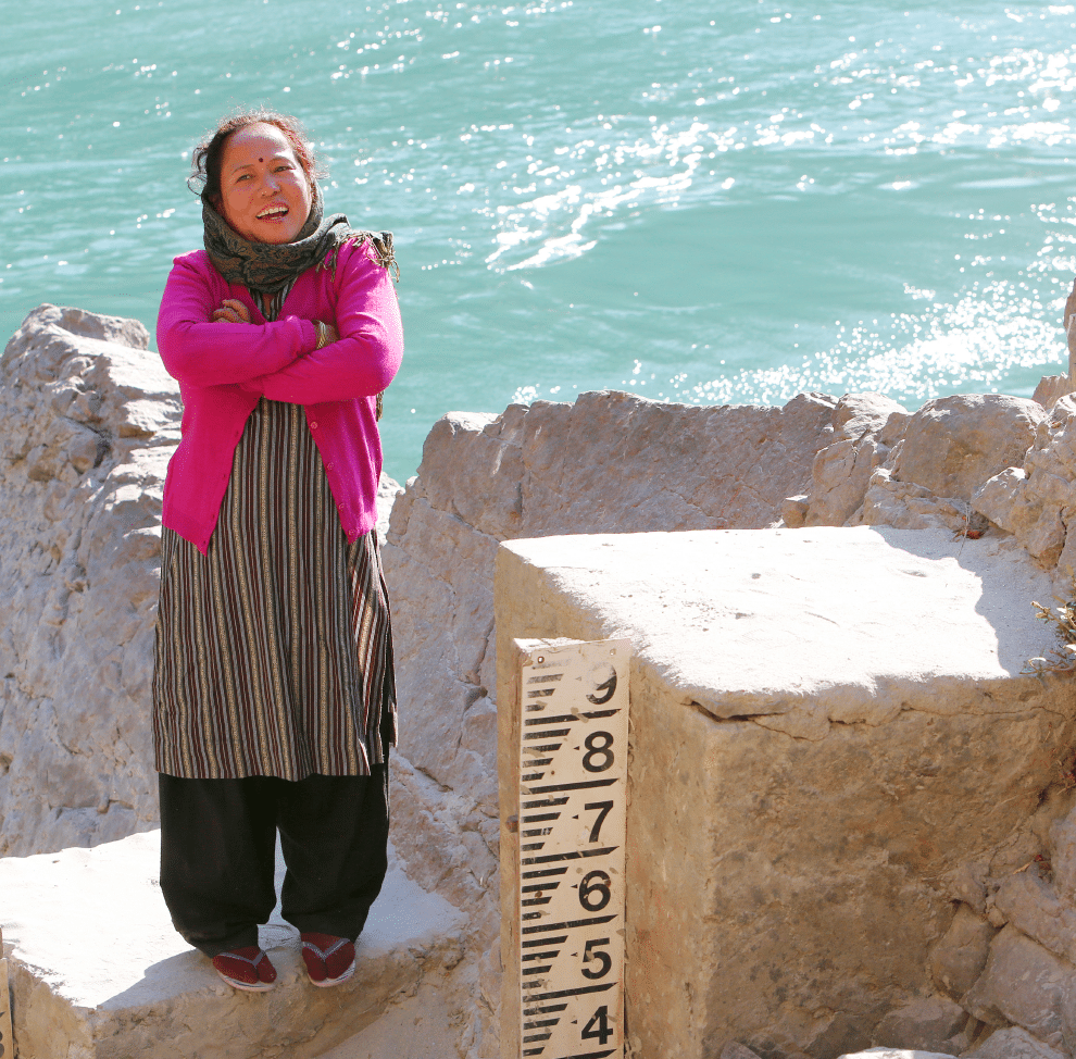 A woman in a pink sweater is participating in the Flood Resilience Programme, which aims to create futures beyond flooding.