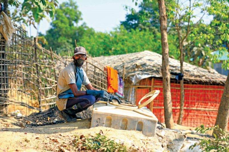 A man adapts in a turbulent year, sitting next to a shack.