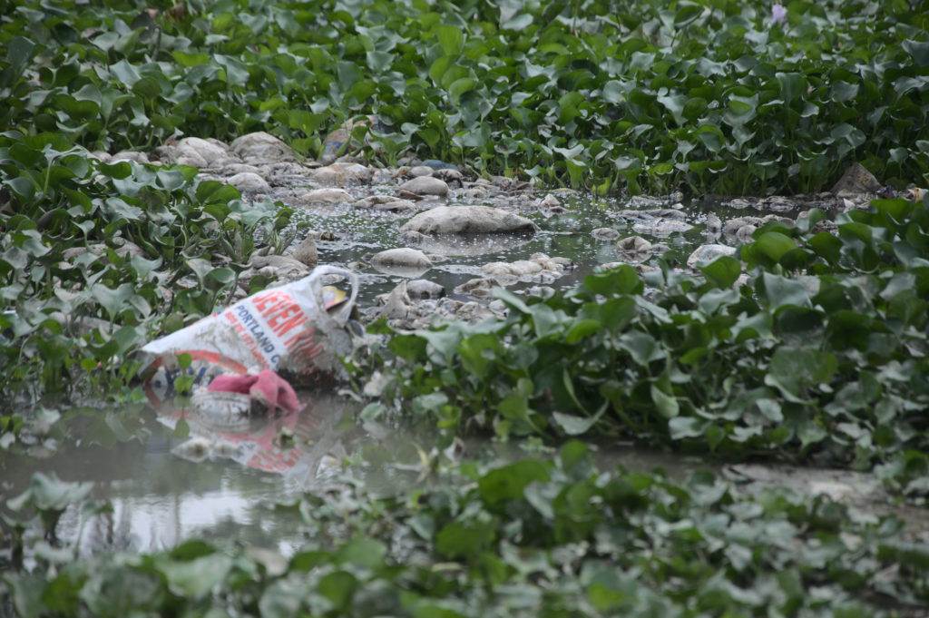 Recycling plastic bag in a muddy field.