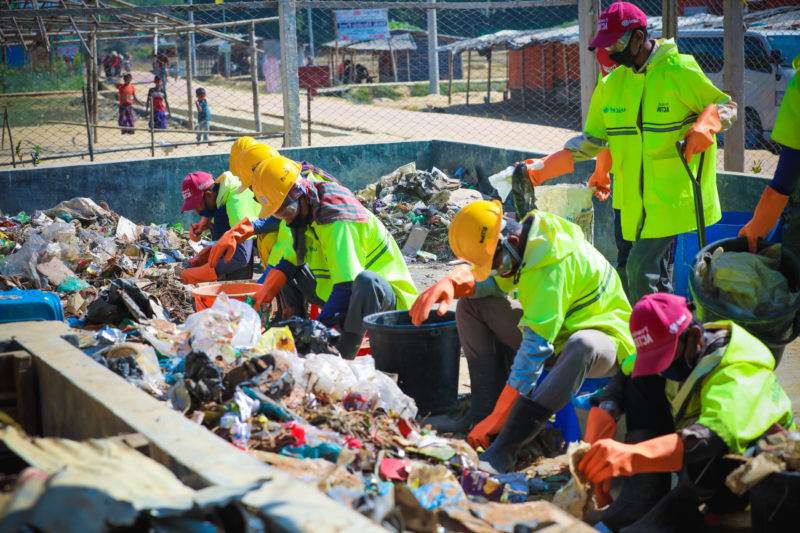 People working through plastic items to recycle them