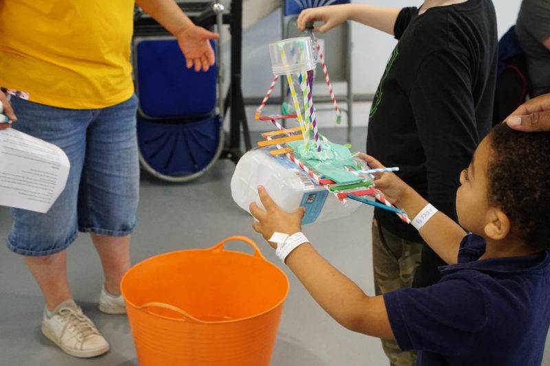 Practical Action at Bluedot 2022 showing a child holding a floating garden item