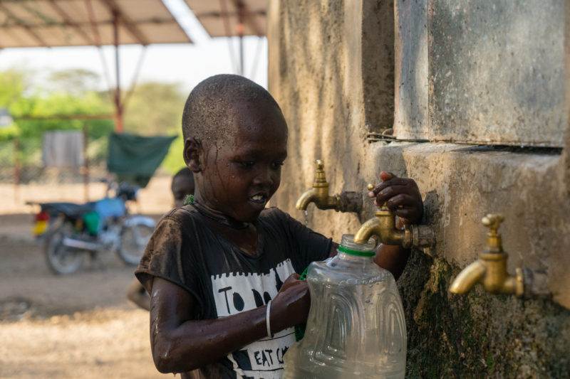 A young boy drinking water.
