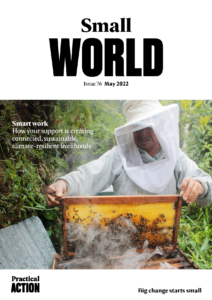 The cover of small world magazine with a man holding a beehive.