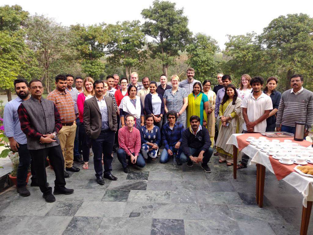 A group of people posing for a picture in front of a table, building resilience.