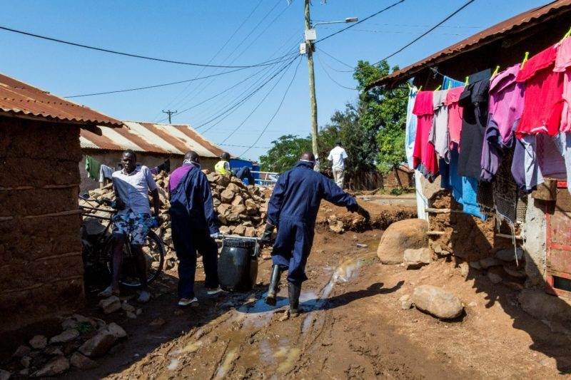 A group of people walking down a dirt road in western Kenya, promoting World Toilet Day 2022 and the urgent need for improved sanitation in urbanizing towns.