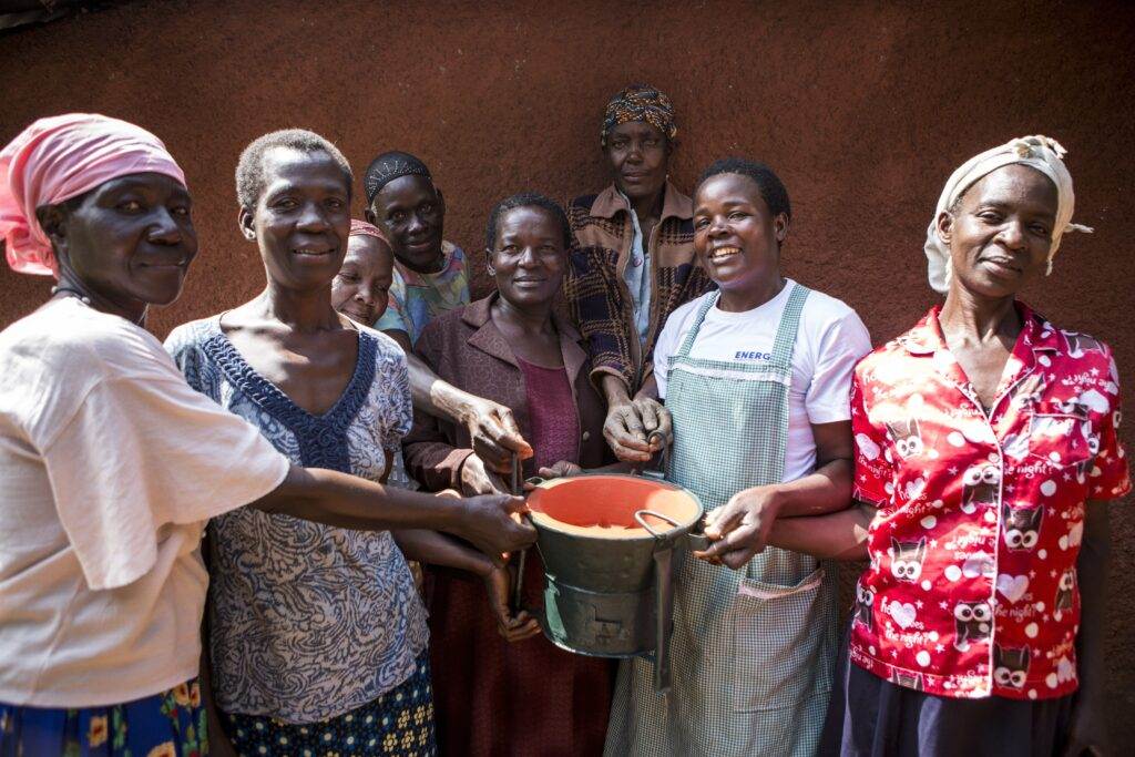 Renowned restaurant, Wahaca, chooses Practical Action to raise money for International Women's Day, with a group of women holding a bucket in front of a house.