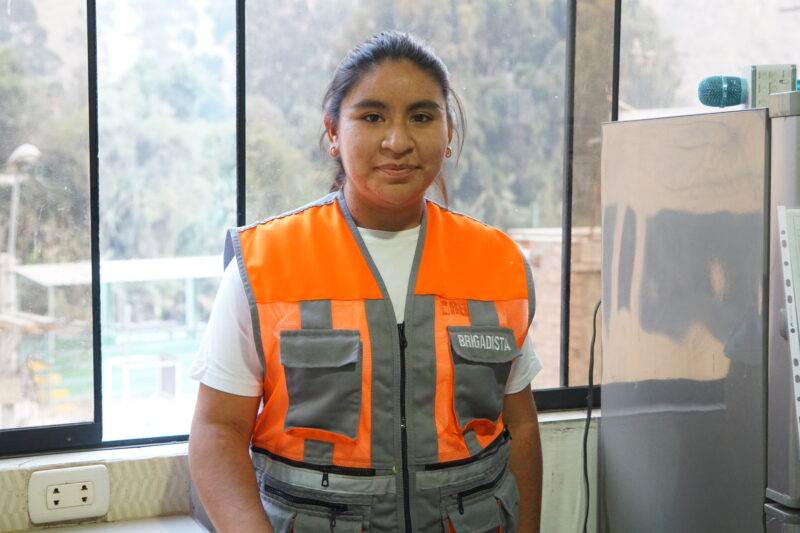 A woman in an orange vest raising awareness about the human impact of the climate crisis.