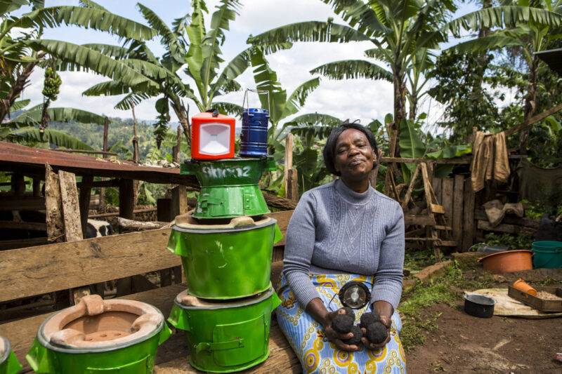 A woman catalyzing economic empowerment by sitting on a pile of pots.