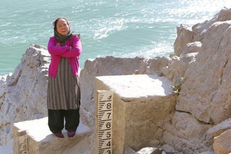 A woman standing by the water, illustrating the human impact of the climate crisis.