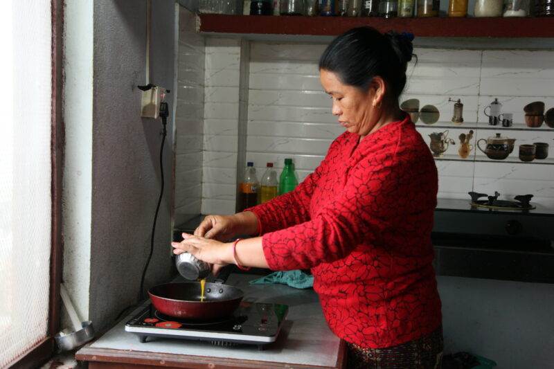 A woman experimenting with an innovative recipe in a kitchen.