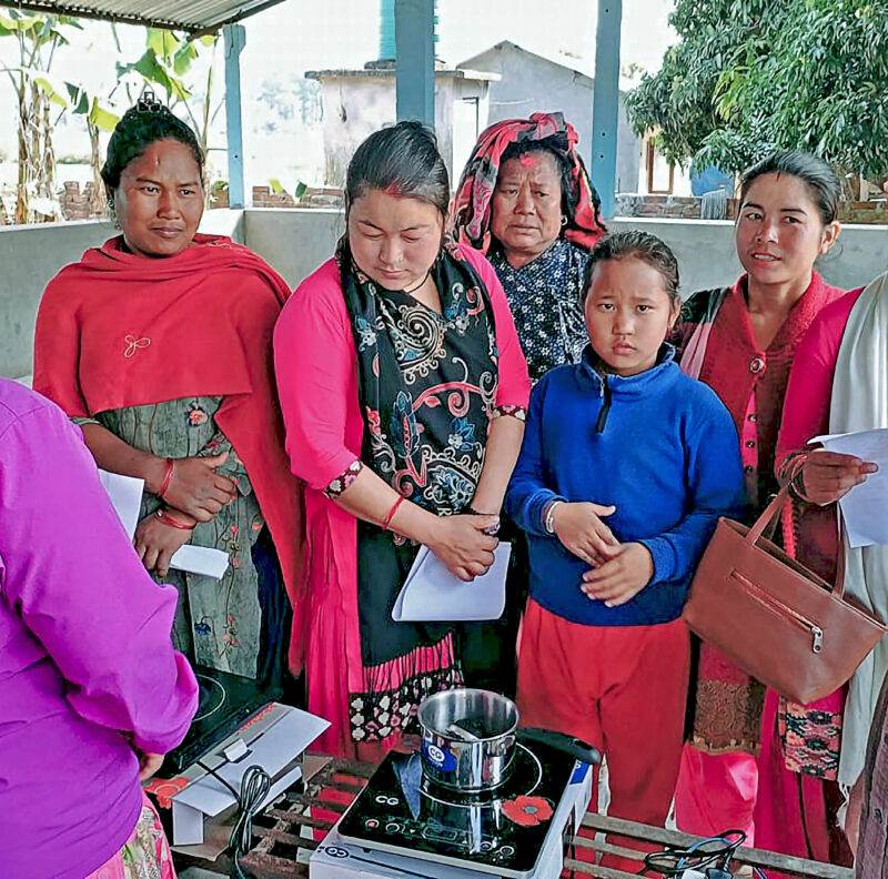 A group of women experimenting with an innovative recipe for cleaner air around a stove.