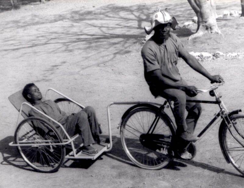 An old photo captures the beauty of a man riding a bicycle with a child in a basket half a decade later.