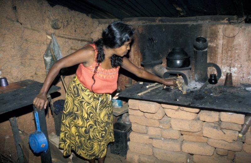 A woman in a small hut preparing food after half a decade.