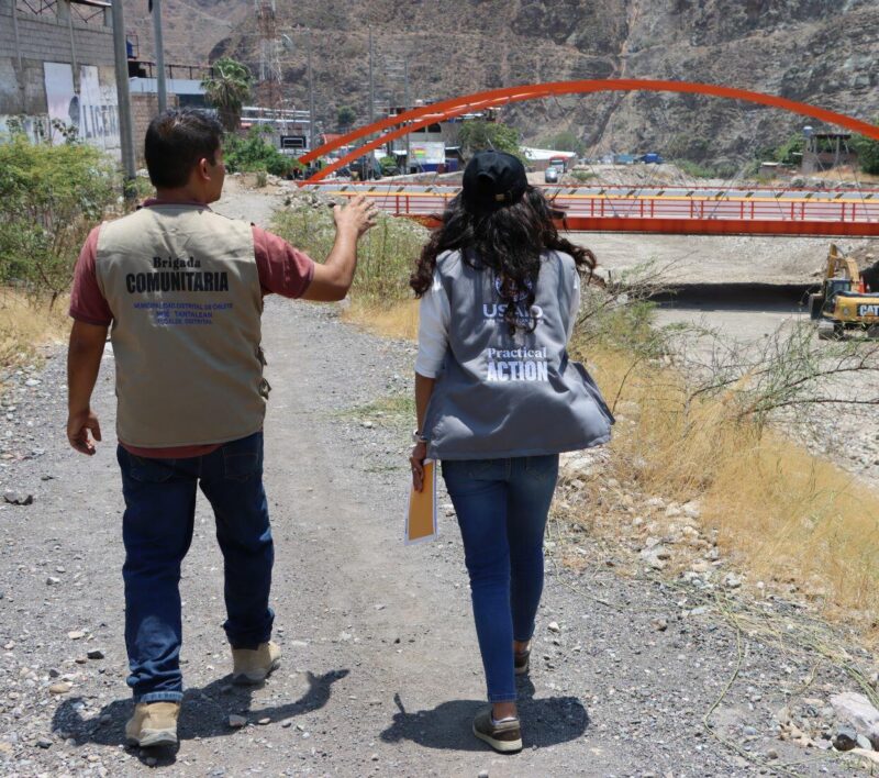 A man and a woman walking down a dirt road, contributing to the journey from vulnerable to resilient communities in Peru (BHA).